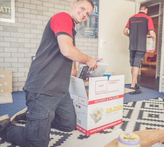 Professionele verhuizer pakt spullen in verhuis- en opslagdozen.