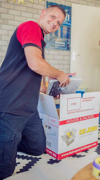 Professionele verhuizer pakt spullen in verhuis- en opslagdozen.